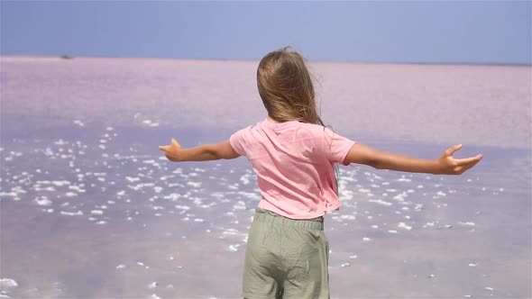 Girl on a Pink Salt Lake on a Sunny Summer Day.