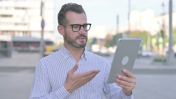 Video Call on Tablet By Young Adult Man Outdoor alt