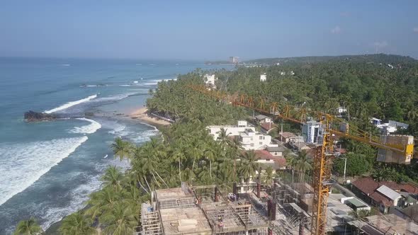 Yellow Crane on Construction Territory Against Green Trees alt