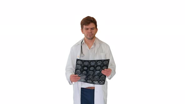 Concentrated Male Doctor Examining Computed Tomography While Walking on White Background. alt