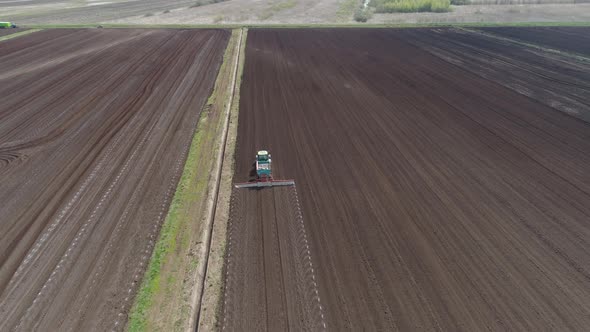 Tractor on Agricultural Lands is Cultivated with Fertilizers alt
