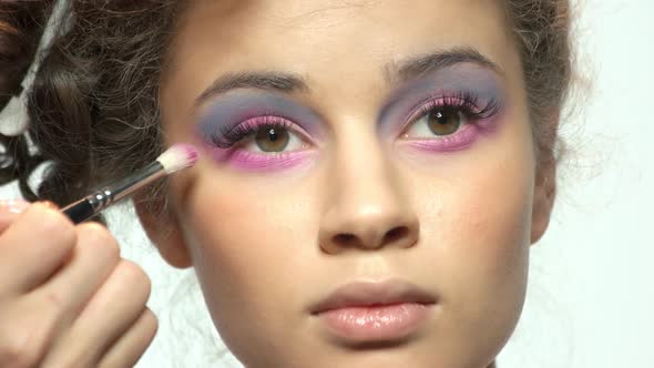 Hand of Visagist Applying Eyeshadow. alt