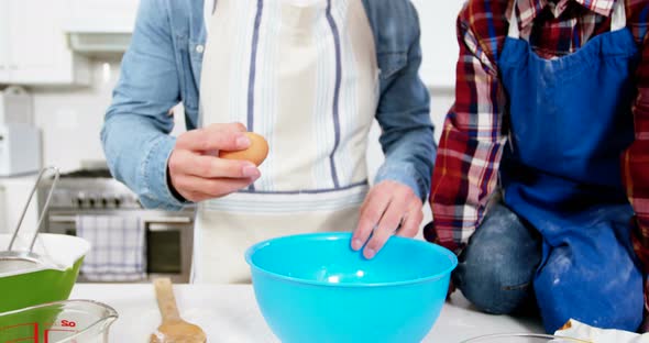 Father teaching his son how to make cupcake alt