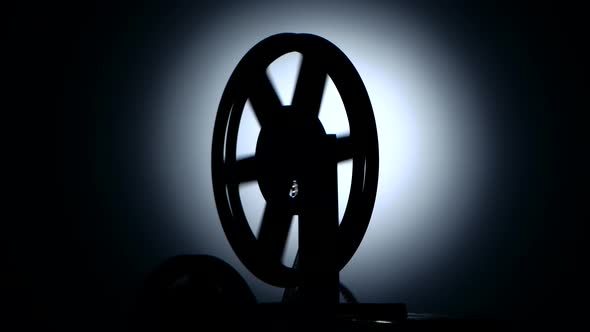Silhouette in a Dark Studio. Bobbin Movie Projector Reels Film alt