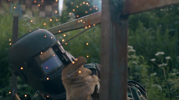 Slow Motion Man Finishes Fence Welding and Looks at Results alt