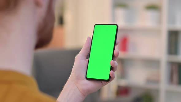 Rear View of Man Using Smartphone with Chroma Screen  alt