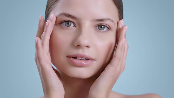 Headshot of Charming Young Woman Touching Her Face While Looking to Camera  alt