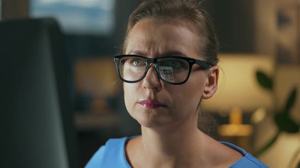 Woman in Glasses Looking on the Monitor and Surfing Internet alt