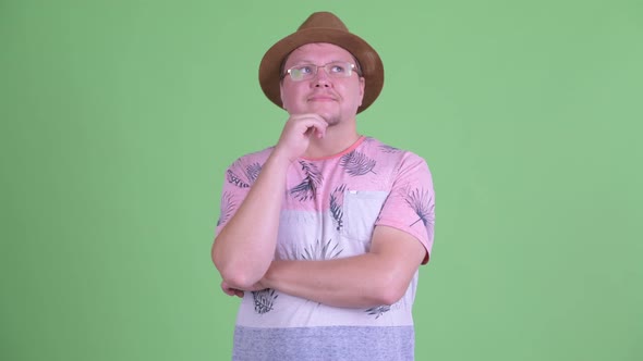 Happy Overweight Bearded Tourist Man Thinking and Looking Up alt