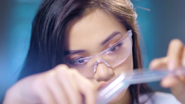 Asian Female Scientist in Glasses Working with Chemical Reagents Closeup Creating Healthcare Product alt
