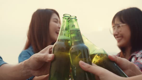 Group of Asia friends focus on couple girls cheers toast of bottle beer enjoy party with happy.