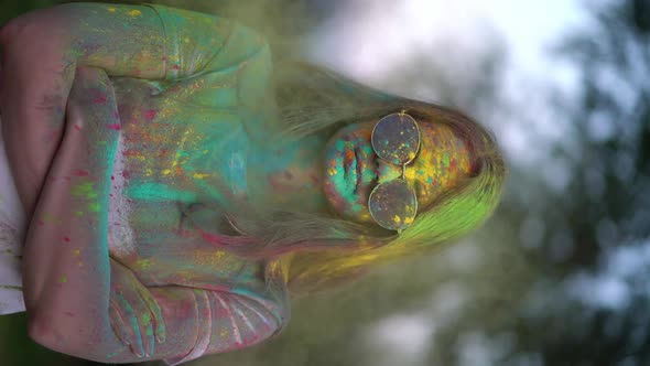 Vertical Video, Portrait of Woman Standing Being Covered in Coloured Powder at Holi Festival alt