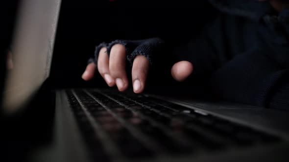 Hacker Hand Stealing Data From Laptop Top Down  alt