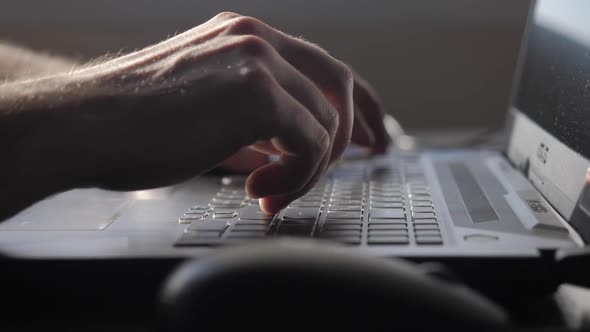 Man's Hands are Typing on the Laptop Keyboard