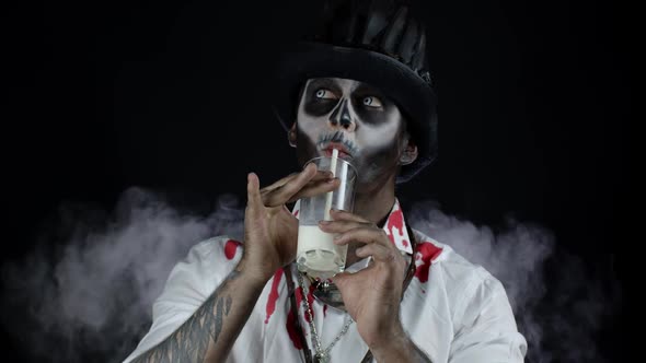 Creepy Man with Skeleton Makeup in White Shirt. Guy Looking at Camera, Drinks Milk From a Glass alt