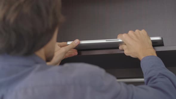 The Young Man Puts All His Electronic Devices in a Closet. Digital Detox Concept alt