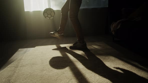Man Minting a Soccer Ball Professional Football Player Training in the Living Room at Home or Office alt