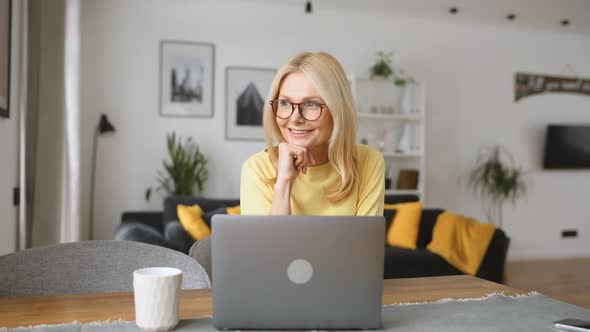 Charming Serene Carefree s Middleaged Blonde Woman Using Laptop for Remote Work
