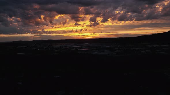 Rising aerial shot of a golden sunset in Spokane, Washington. alt