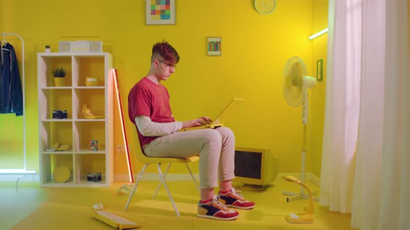 Man Is Typing On Yellow Laptop