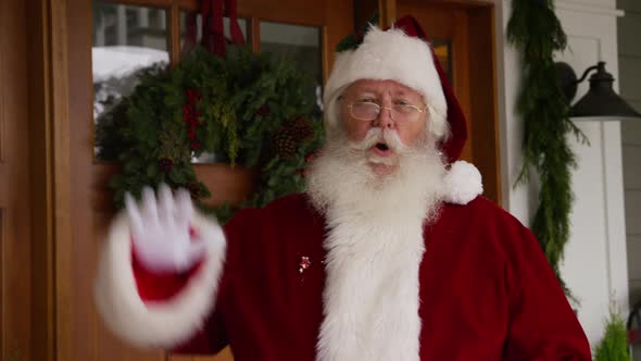 Santa Claus waving by front door alt