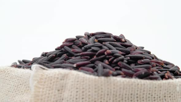 Macro shot of Black rice berry in bag on white background, Rotation shot, Close up.