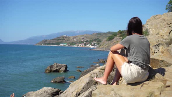 Tourist Woman Outdoor on Edge of Cliff Seashore