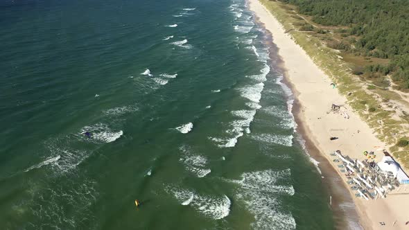 AERIAL: Rotating Shot of Waves Crashing on a Beach From Very High Altitude