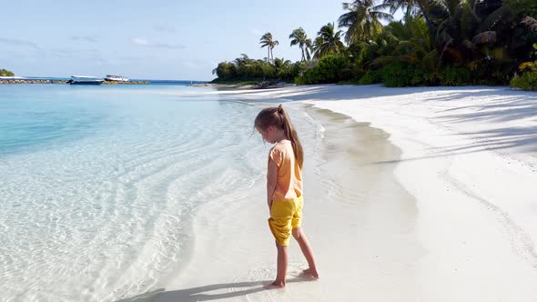 Little girl playing on the ocean beach