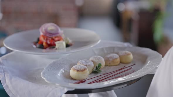 Closeup White Plates with Dessert and Salad on Tray in Male Caucasian Hand alt