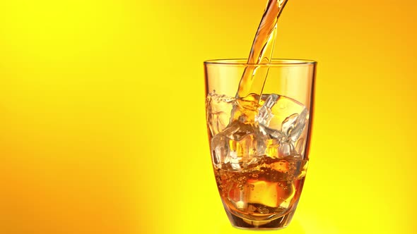 Super Slow Motion Shot of Pouring Fresh Ice Tea Into Glass with Ice Cubes at 1000 Fps alt