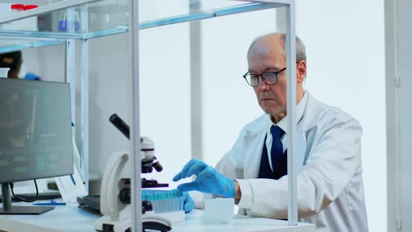 Elderly Man Scientist Doing Research Analysing Liquid in Tube at Laboratory alt