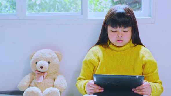 Asian girls study online and watch the tablet at home
