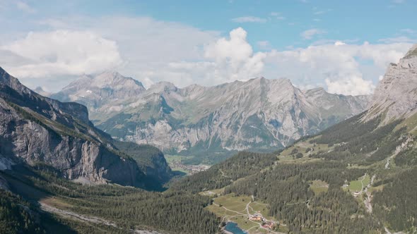 Dolly forward drone shot over Blue Lake Oeschinen towards Kandersteg Swiss mountains alt