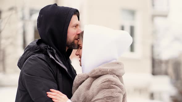 Beautiful Man and Woman in the Winter on the Street Froze and Put on Hoods alt