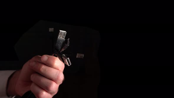 Many Usb Connectors In Hand On A Black Background