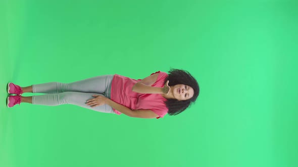 Portrait of Young Female African American Smiling and Showing Heart with Fingers Then Blowing Kiss alt