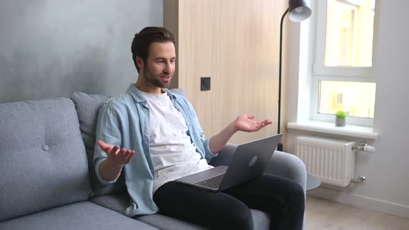 Young Goodlooking Man is Using a Laptop for Video Connection Making Real Call
