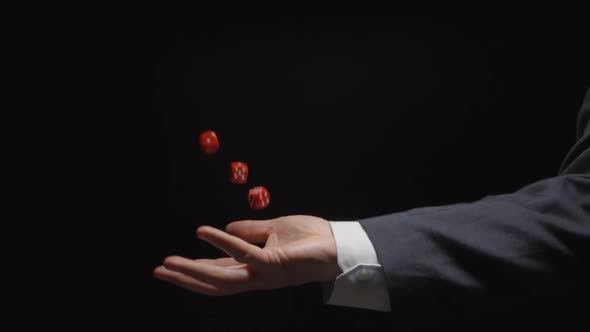 Businessman hand throws up several red playing cubes