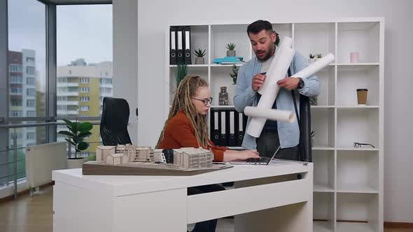 Architect Carrying Different Blueprints to His Strict Concentrated Successful Modern Female Chief alt