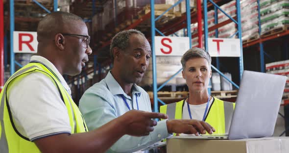 Warehouse staff meeting around a laptop 4k alt