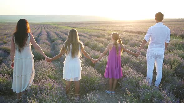 Family in Lavender Flowers Field on the Sunset