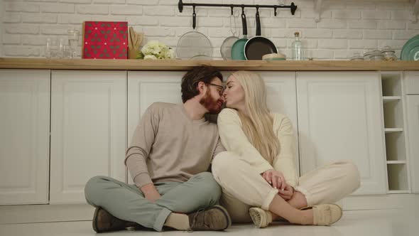 Portrait of a Millennial European Couple Sitting on the Floor Contemplating and Being Intimate alt