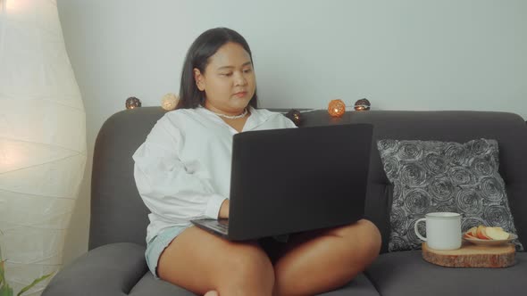 Asian Plus Size Woman Working Online with Laptop at Home alt
