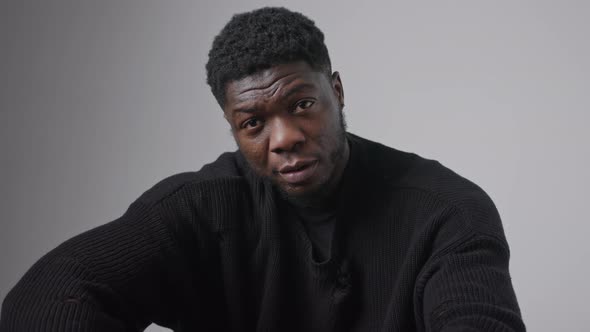 Close Up Studio Shot on Grey Background of a Confident Seductive Middleaged Black Guy Touching His alt