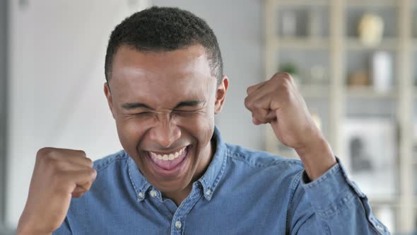 Young African Man Celebrating Success  Gesture in Office alt