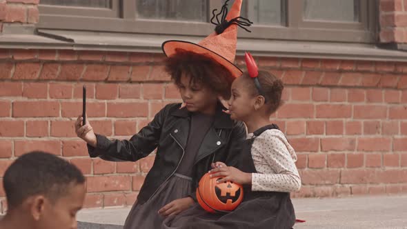 Girls in Halloween Costumes Taking Selfie Outdoors alt