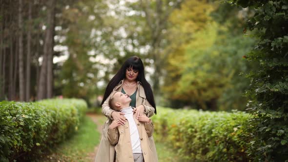 Mom and Son are Walking in the Park in Autumn