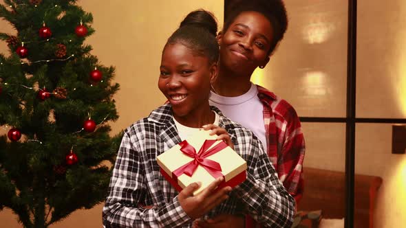 Two Young Married Thankful Women Talking with Subscribers with Gift Box at Home alt
