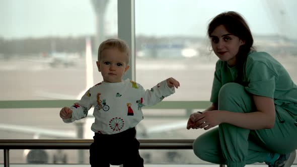 Toddler Boy Running From Mom to Camera in Airport alt